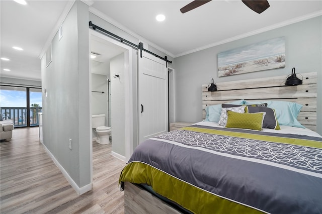 bedroom with ornamental molding, ensuite bathroom, ceiling fan, light hardwood / wood-style flooring, and a barn door