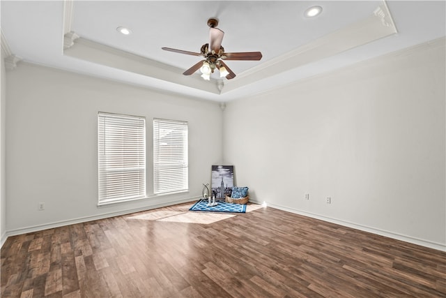 unfurnished room with hardwood / wood-style flooring, a raised ceiling, ceiling fan, and crown molding