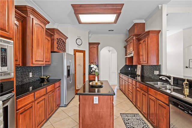 kitchen with sink, a center island, decorative backsplash, appliances with stainless steel finishes, and ornamental molding