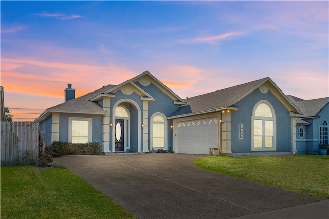 view of front of home with a yard and a garage