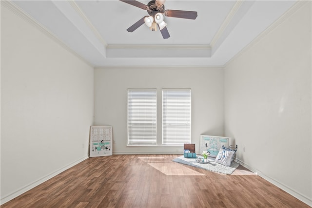 unfurnished room with hardwood / wood-style flooring, a tray ceiling, crown molding, and ceiling fan