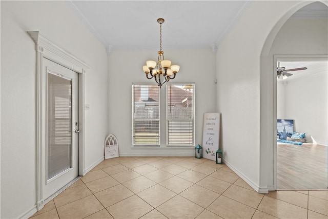 unfurnished dining area with ceiling fan with notable chandelier, ornamental molding, and light tile patterned floors