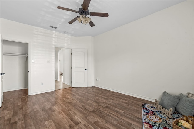 unfurnished bedroom with ceiling fan, dark hardwood / wood-style flooring, and a closet