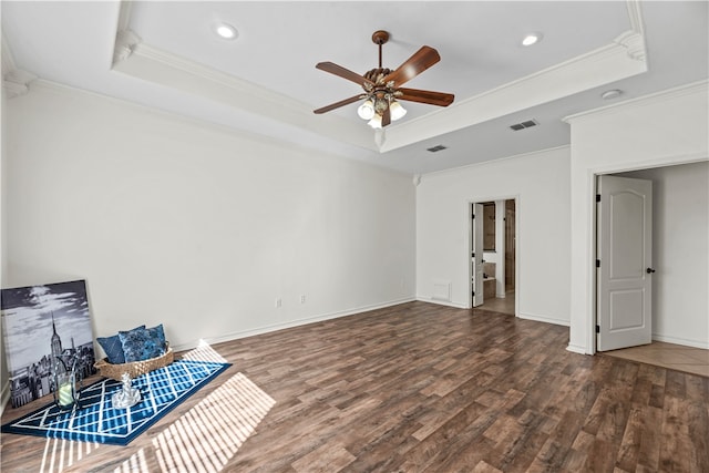 unfurnished living room with a tray ceiling, crown molding, ceiling fan, and dark hardwood / wood-style floors