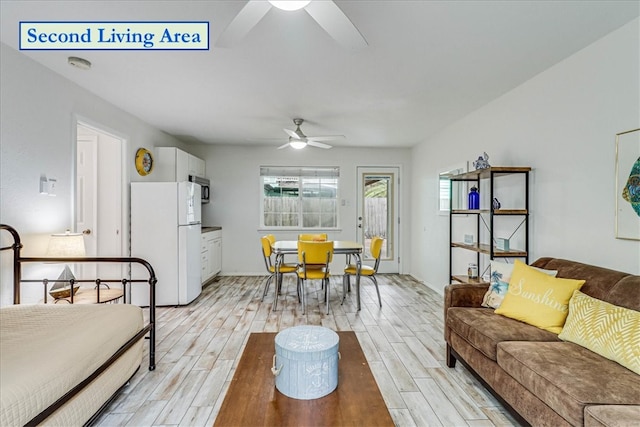 living room with light hardwood / wood-style floors and ceiling fan