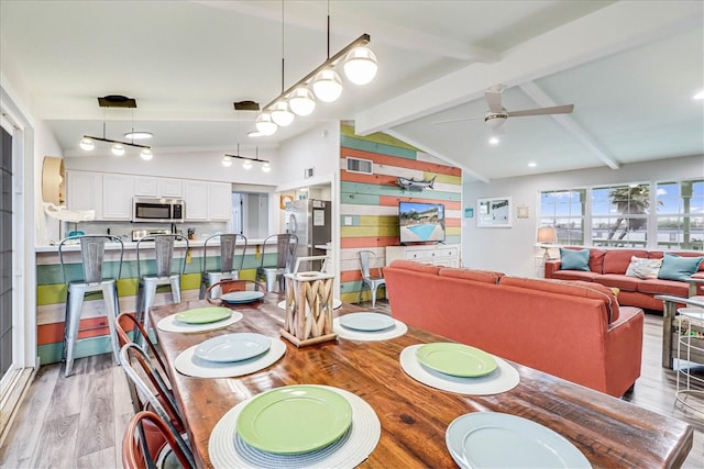 dining space with lofted ceiling with beams, wooden walls, ceiling fan, and light hardwood / wood-style flooring