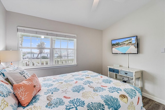 bedroom with ceiling fan, lofted ceiling, and wood-type flooring