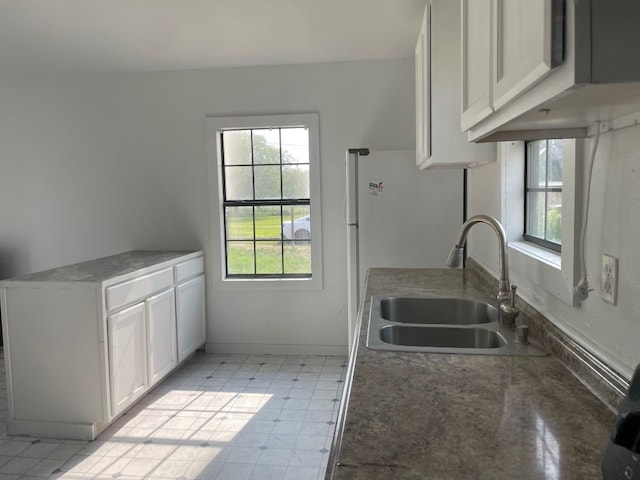 kitchen featuring a healthy amount of sunlight, sink, and white cabinets