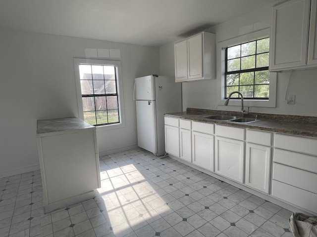 kitchen with white cabinetry, a wealth of natural light, sink, and white refrigerator