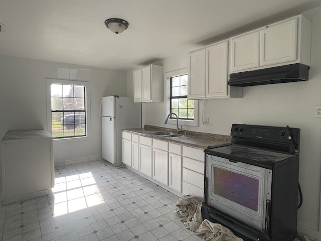 kitchen featuring sink, white cabinetry, white refrigerator, and black / electric stove