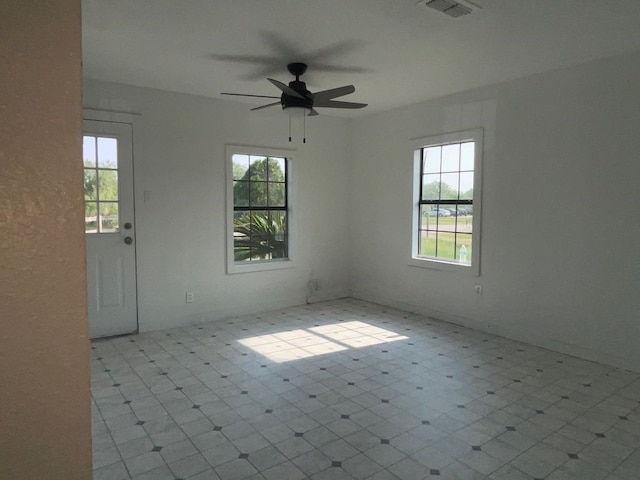 empty room with ceiling fan and a healthy amount of sunlight