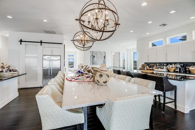 602 Banyan Beach Dr, Port Aransas, TX 78373 - dining area with a barn door, dark wood-style flooring, a chandelier, and recessed lighting