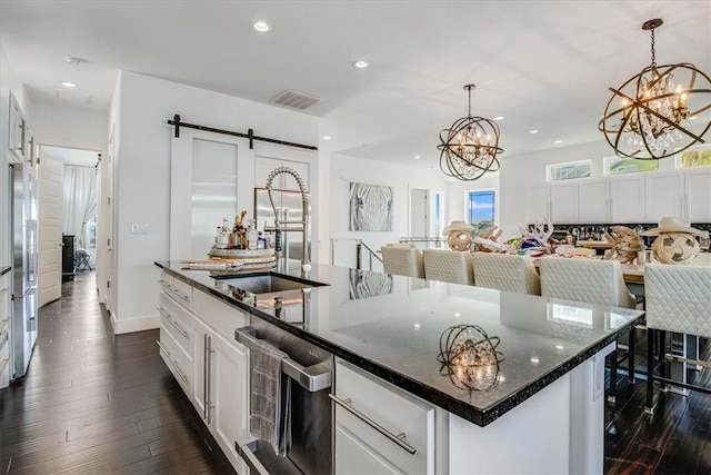 602 Banyan Beach Dr, Port Aransas, TX 78373 - kitchen with stainless steel appliances, a chandelier, a barn door, recessed lighting, and white cabinetry