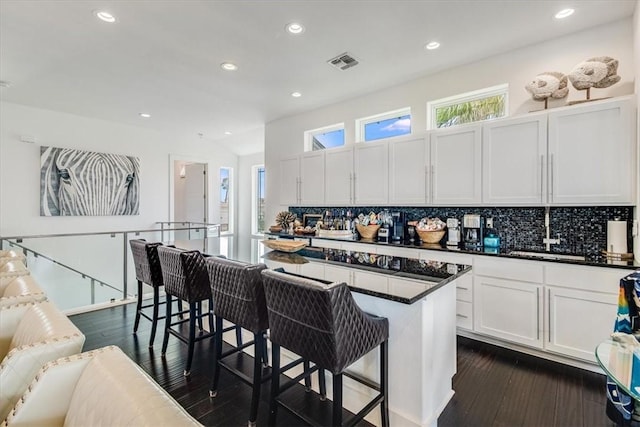 602 Banyan Beach Dr, Port Aransas, TX 78373 - kitchen with dark countertops, recessed lighting, decorative backsplash, a breakfast bar area, and dark wood finished floors