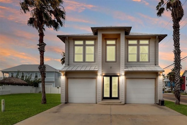 602 Banyan Beach Dr, Port Aransas, TX 78373 - view of front of house featuring an attached garage, driveway, a standing seam roof, and a metal roof