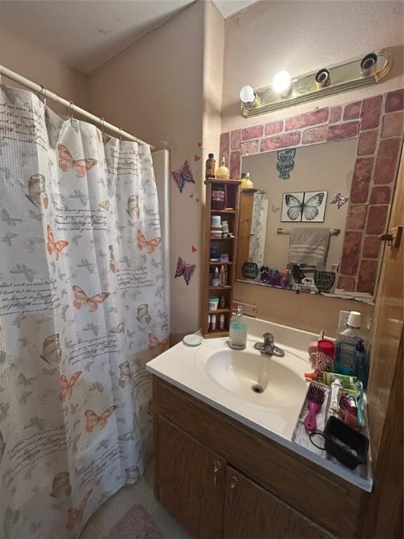 bathroom featuring vanity and curtained shower