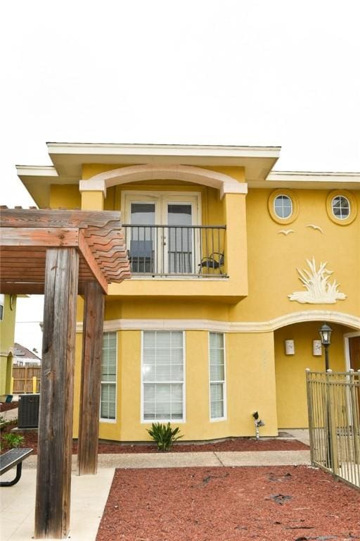 back of property with cooling unit and a balcony