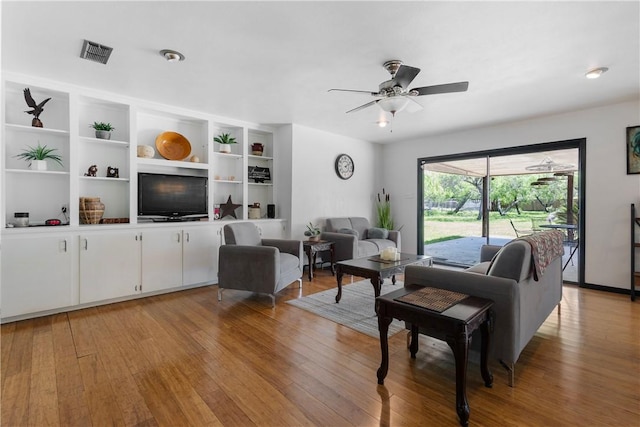 living area with light wood-style flooring, visible vents, and ceiling fan