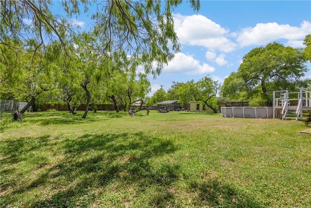 view of yard featuring a fenced in pool and fence
