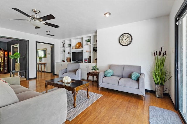 living room featuring light wood-style flooring and a ceiling fan
