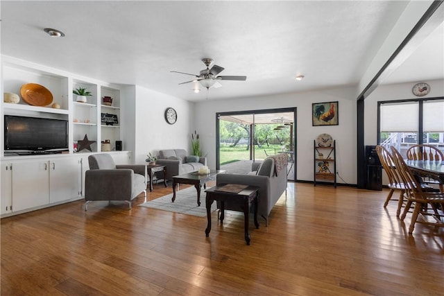 living area featuring a ceiling fan and wood finished floors