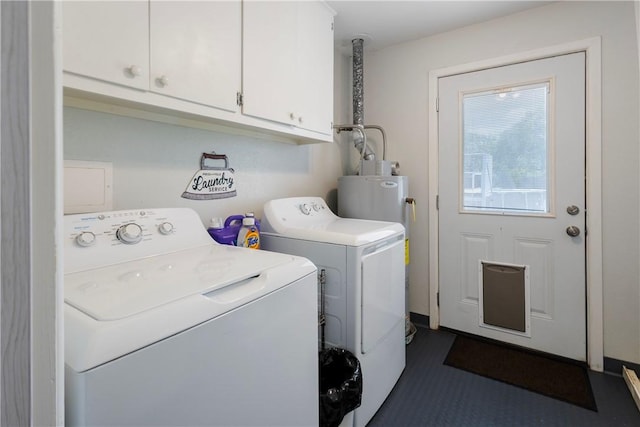 clothes washing area featuring water heater, washer and dryer, and cabinet space