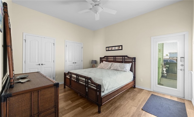 bedroom featuring wood-type flooring, two closets, and ceiling fan