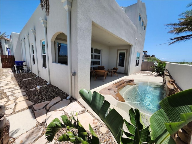 exterior space with a patio, a fenced backyard, and stucco siding