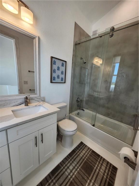 full bathroom featuring toilet, tile patterned floors, enclosed tub / shower combo, and vanity