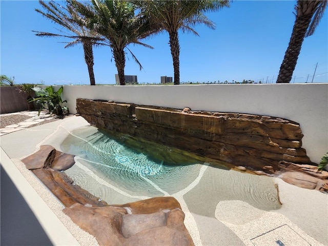 view of swimming pool featuring a patio area and fence