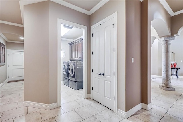 corridor featuring baseboards, ornate columns, arched walkways, ornamental molding, and washer and dryer