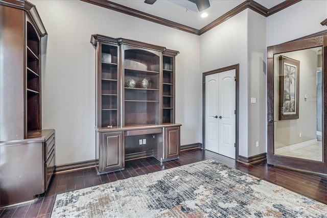 unfurnished office with a ceiling fan, dark wood-type flooring, crown molding, and baseboards