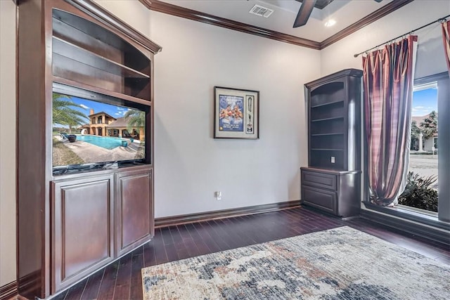 unfurnished office featuring visible vents, crown molding, ceiling fan, baseboards, and dark wood-style floors