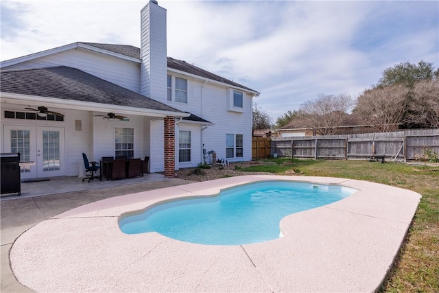 view of swimming pool featuring a fenced in pool, a ceiling fan, a fenced backyard, french doors, and a patio area