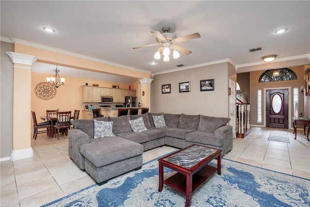 living room featuring light tile patterned floors, visible vents, ornamental molding, and ornate columns