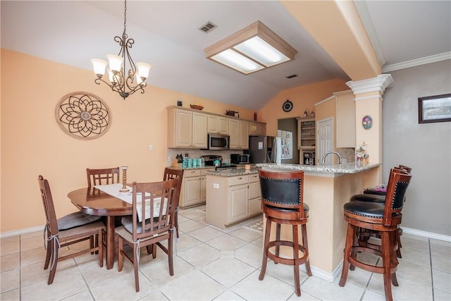 kitchen with lofted ceiling, a peninsula, visible vents, a kitchen breakfast bar, and appliances with stainless steel finishes