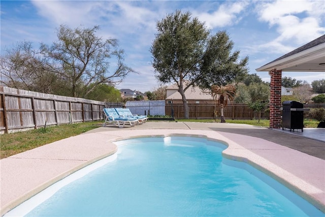 view of pool with a fenced in pool, a patio area, a fenced backyard, and grilling area