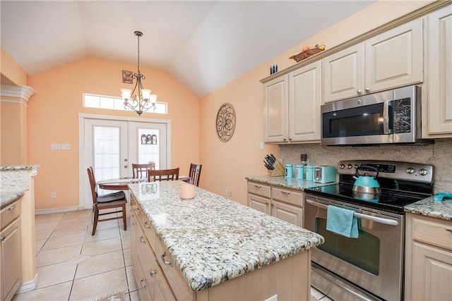 kitchen featuring lofted ceiling, appliances with stainless steel finishes, decorative backsplash, and french doors