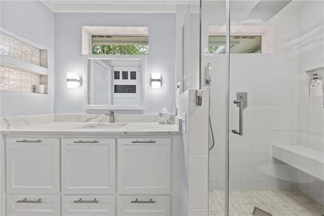 bathroom with a shower with door and vanity