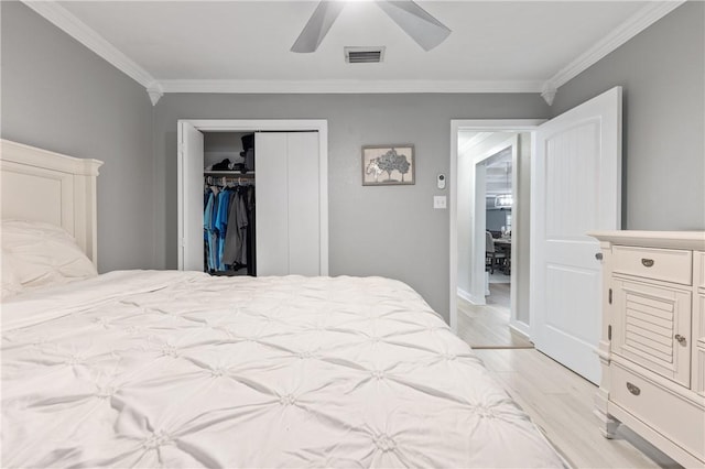 bedroom with crown molding, ceiling fan, a closet, and light hardwood / wood-style floors