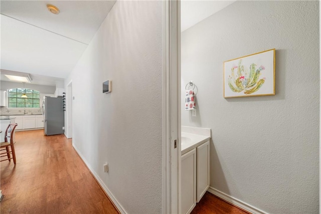 4442 Lake Superior Dr, Corpus Christi, TX 78413 - hallway with light wood-style floors, a textured wall, and baseboards