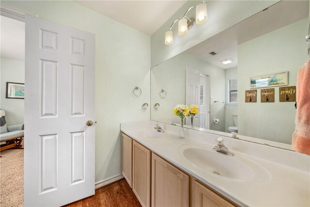 4442 Lake Superior Dr, Corpus Christi, TX 78413 - bathroom with toilet, double vanity, and wood finished floors
