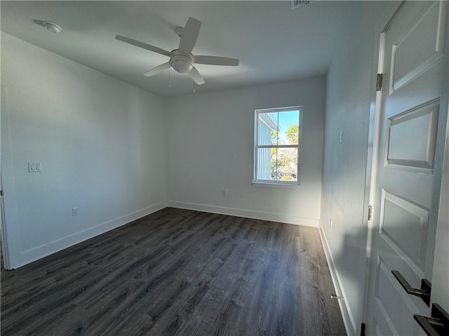 empty room with a ceiling fan, dark wood-type flooring, and baseboards