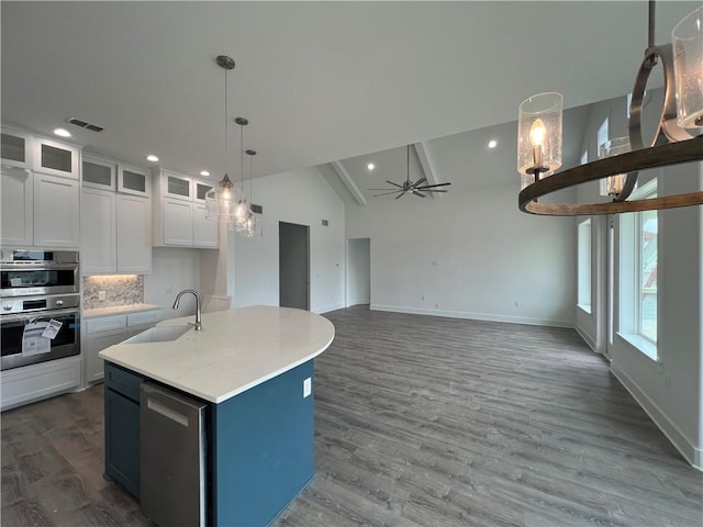 kitchen with a ceiling fan, a sink, backsplash, white cabinetry, and stainless steel appliances