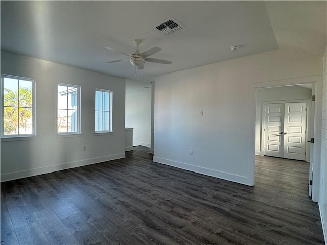 unfurnished room featuring visible vents, baseboards, dark wood-style flooring, and a ceiling fan