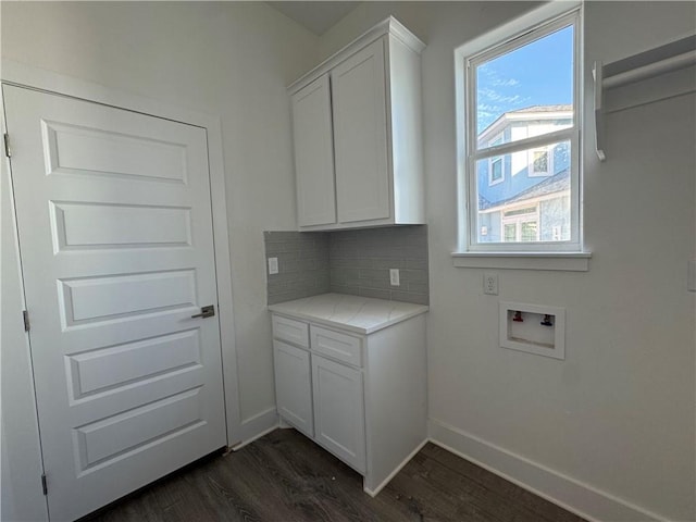 clothes washing area featuring cabinet space, hookup for a washing machine, dark wood-type flooring, and baseboards