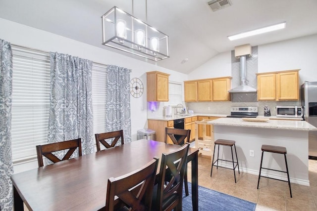 tiled dining area with lofted ceiling and sink