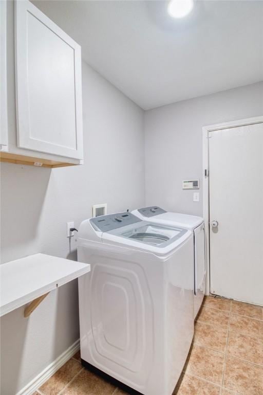 laundry room featuring cabinets, separate washer and dryer, and light tile patterned floors