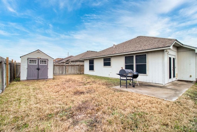 rear view of property featuring a storage unit, a patio, and a lawn