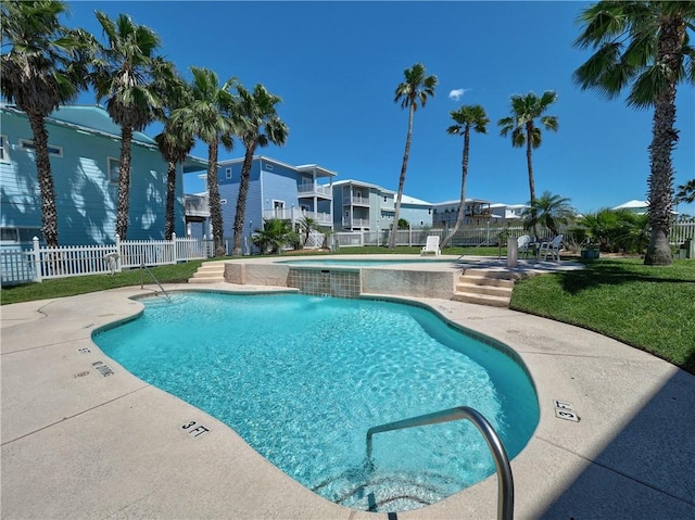 view of swimming pool featuring a yard, pool water feature, and a patio